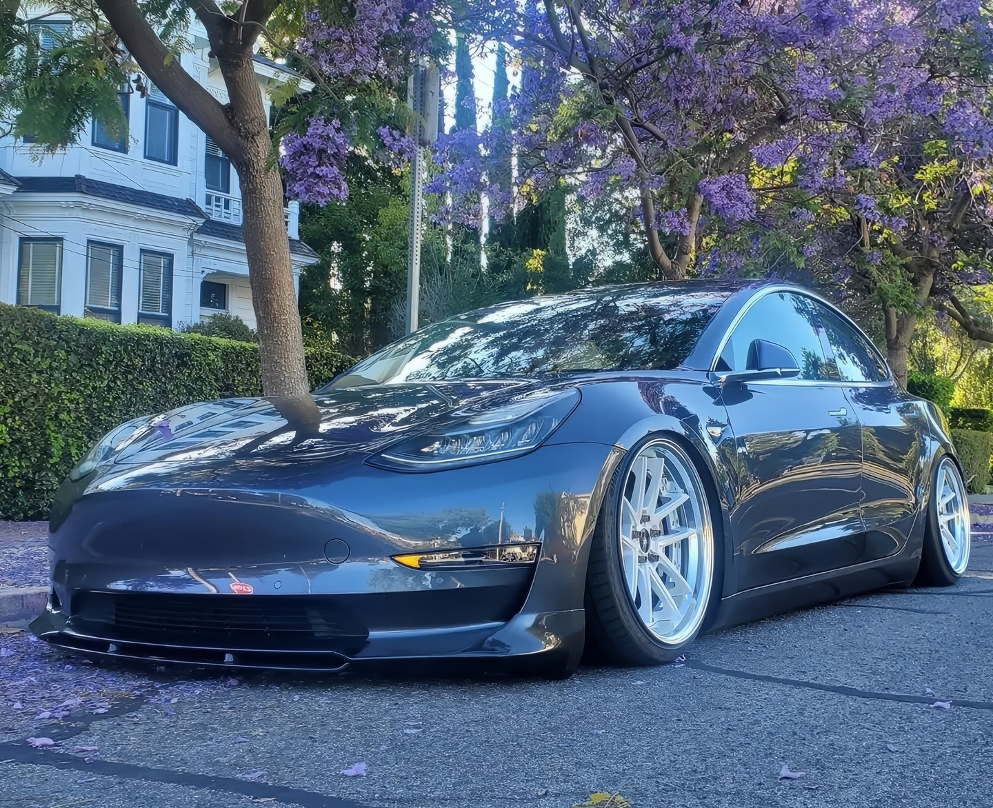 Lowered vehicle with aftermarket wheels showing a deep, corrected paint finish